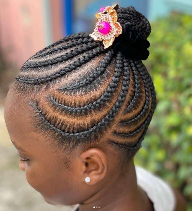 Side-swept cornrows into a bun with flower clip